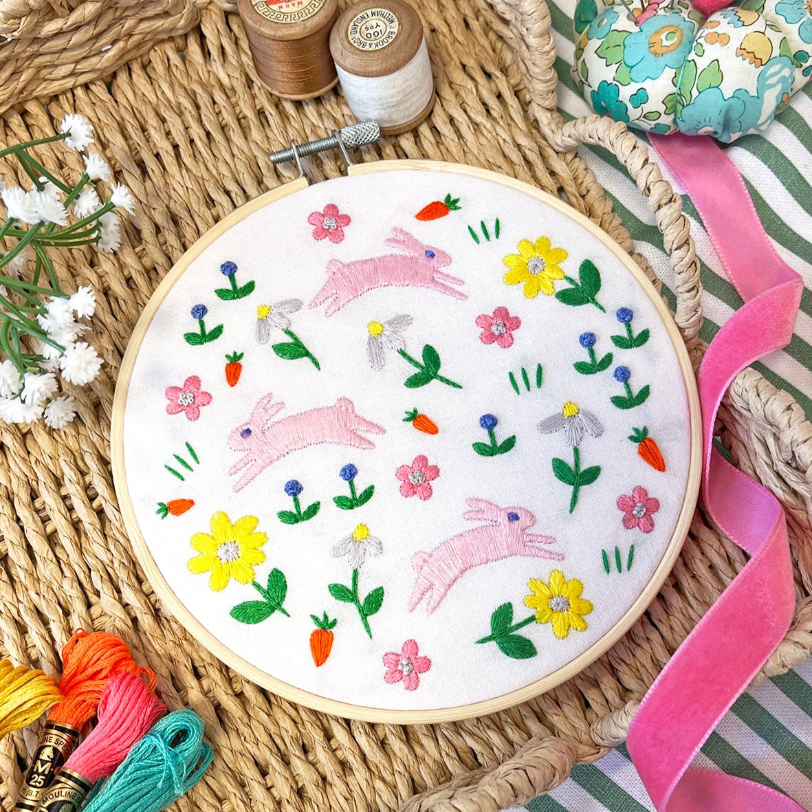 embroidery kit with bright coloured flowers and pink leaping bunnies